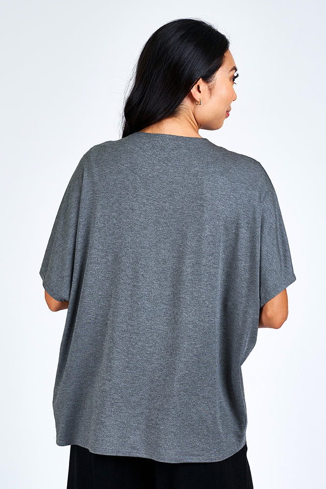 Woman wearing grey cardigan.