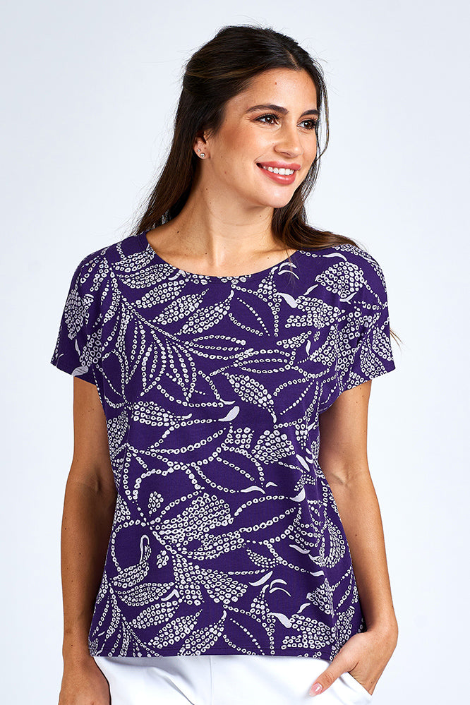 Woman wearing a purple and white short sleeve top.