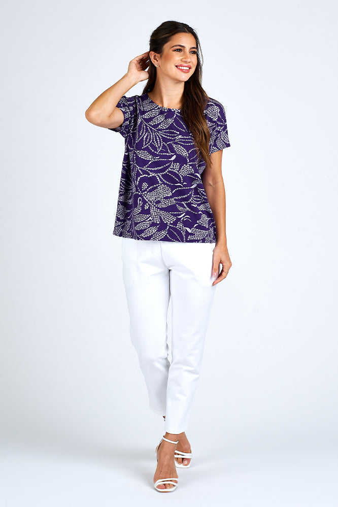 Woman wearing a purple and white short sleeve top.