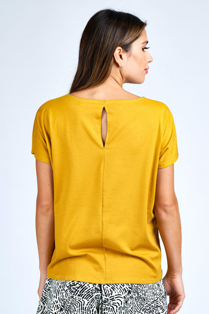 Woman wearing yellow short sleeve top.