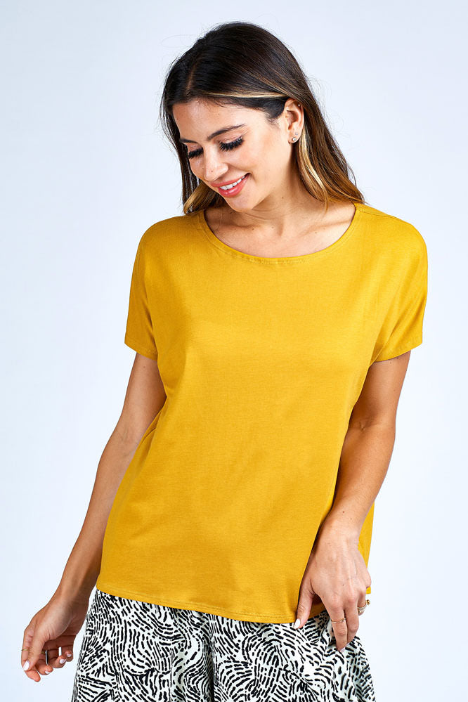Woman wearing yellow short sleeve top.