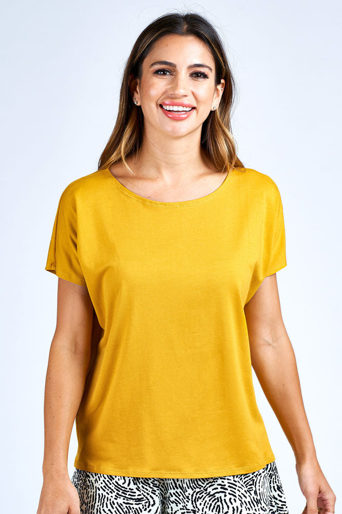 Woman wearing yellow short sleeve top.