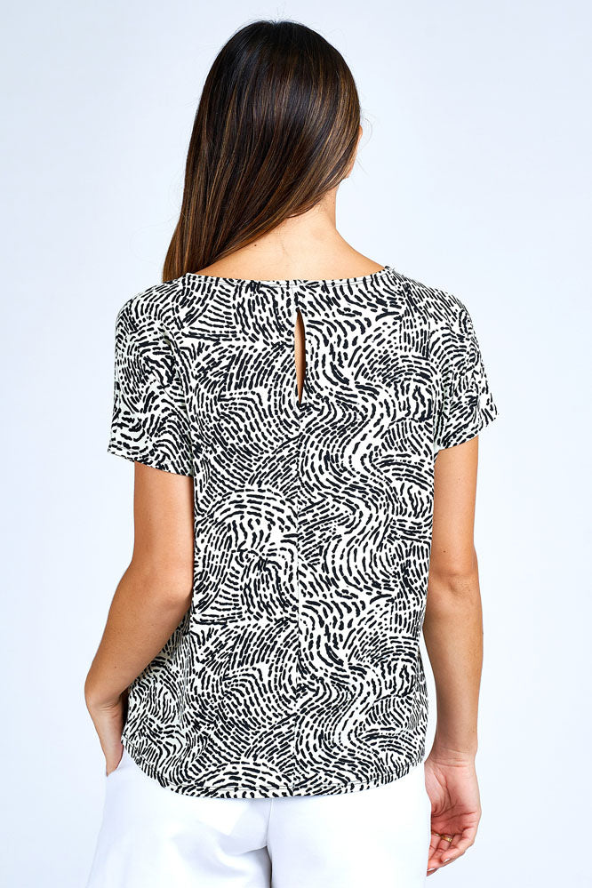 Woman wearing grey and white short sleeve top.