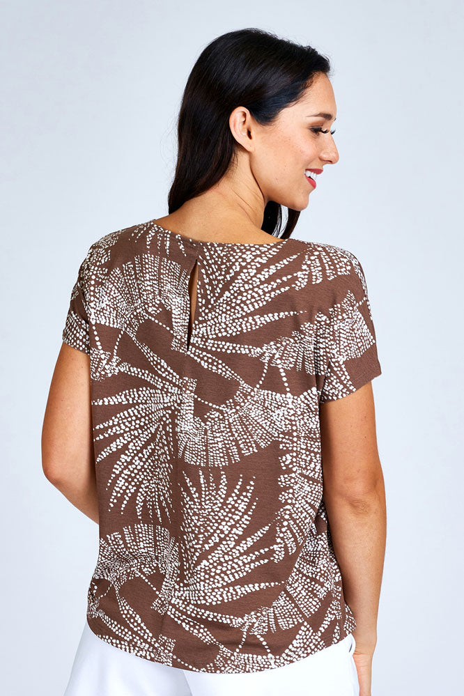 Woman wearing brown and white top.