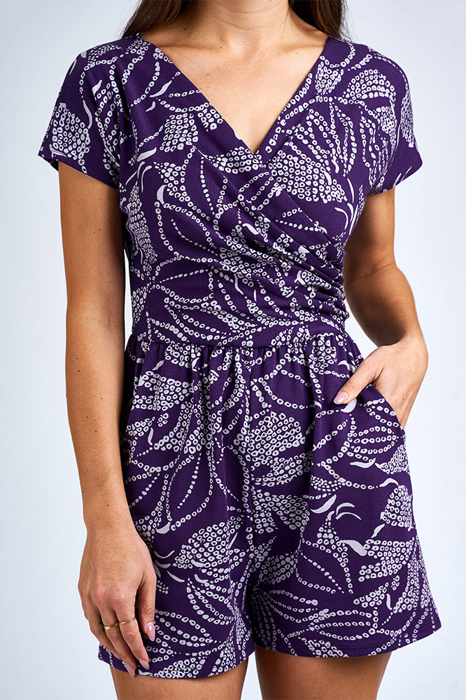 Woman wearing purple and white romper.