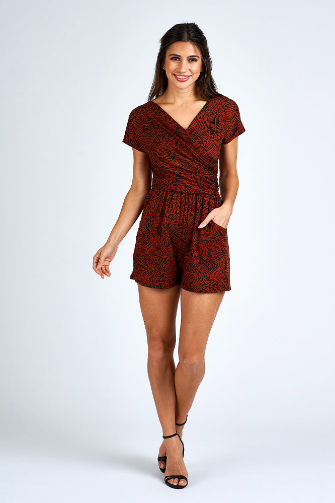 Woman wearing an orange and black romper.