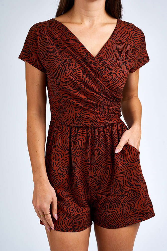 Woman wearing an orange and black romper.