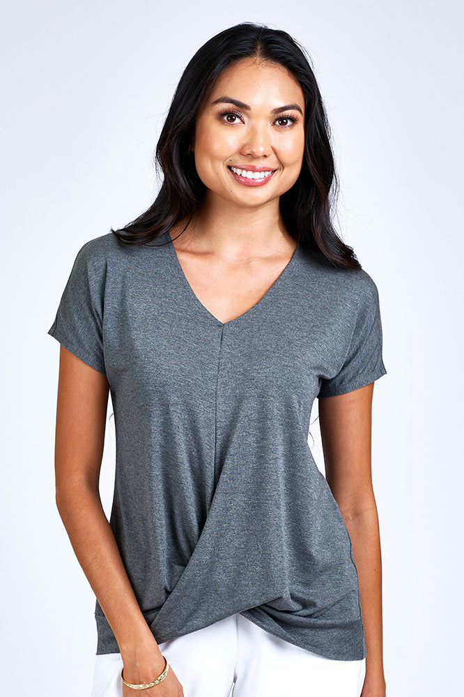 Woman wearing grey short sleeve top.