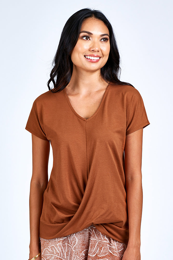 Woman wearing rust short sleeve top.