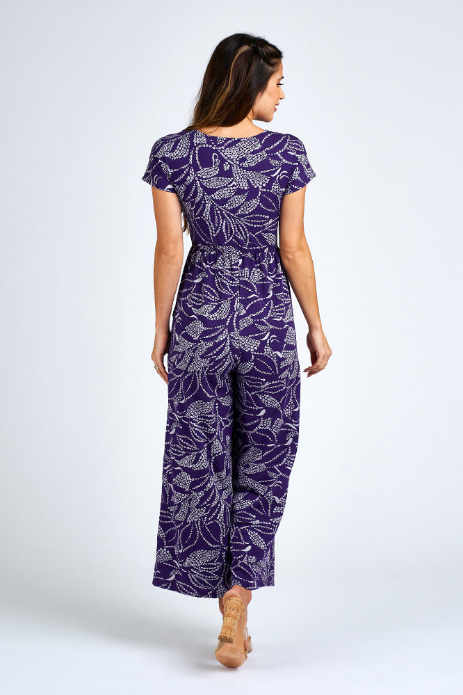 Woman wearing purple and white jumpsuit.