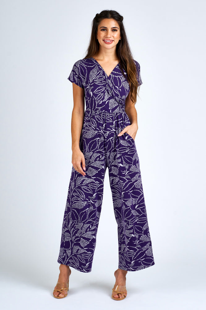 Woman wearing purple and white jumpsuit.