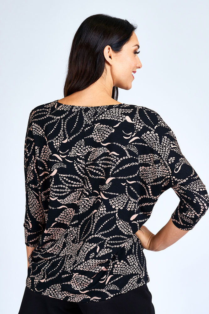 Woman wearing black and cream 3/4 sleeve top.