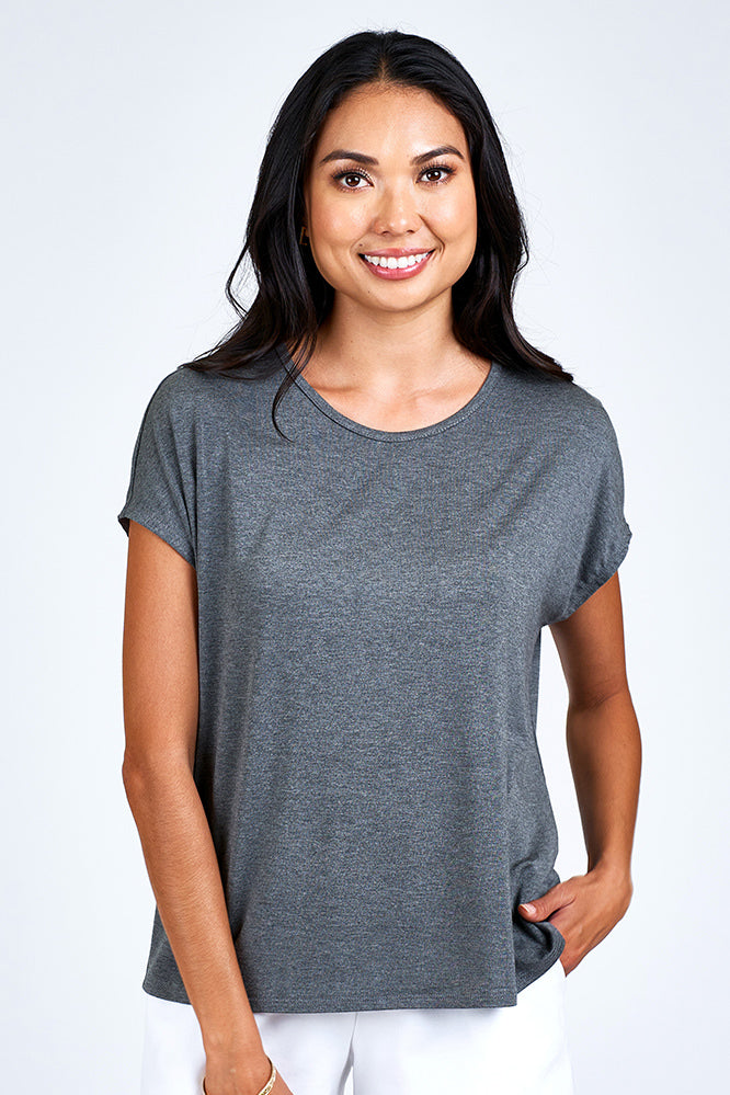 Woman wearing grey short sleeve top.