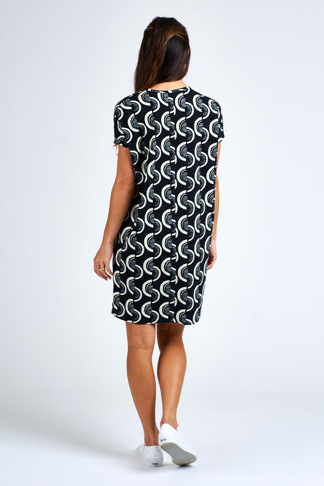 Woman wearing above knee black and white dress.