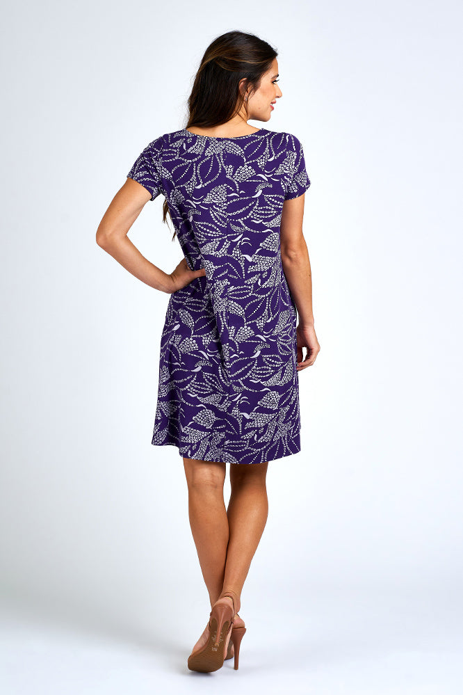 Woman wearing above knee purple and white dress.