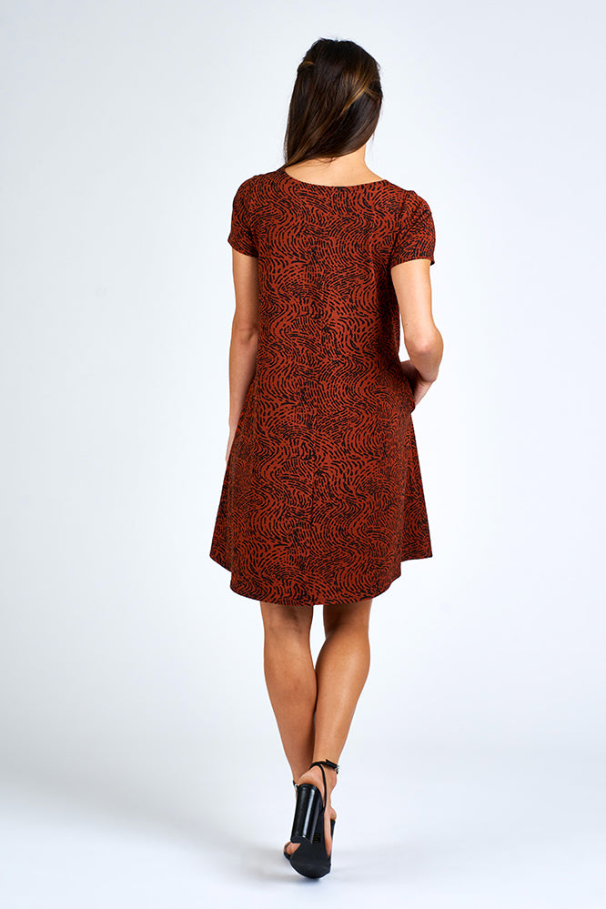 Woman wearing above knee black and orange dress.