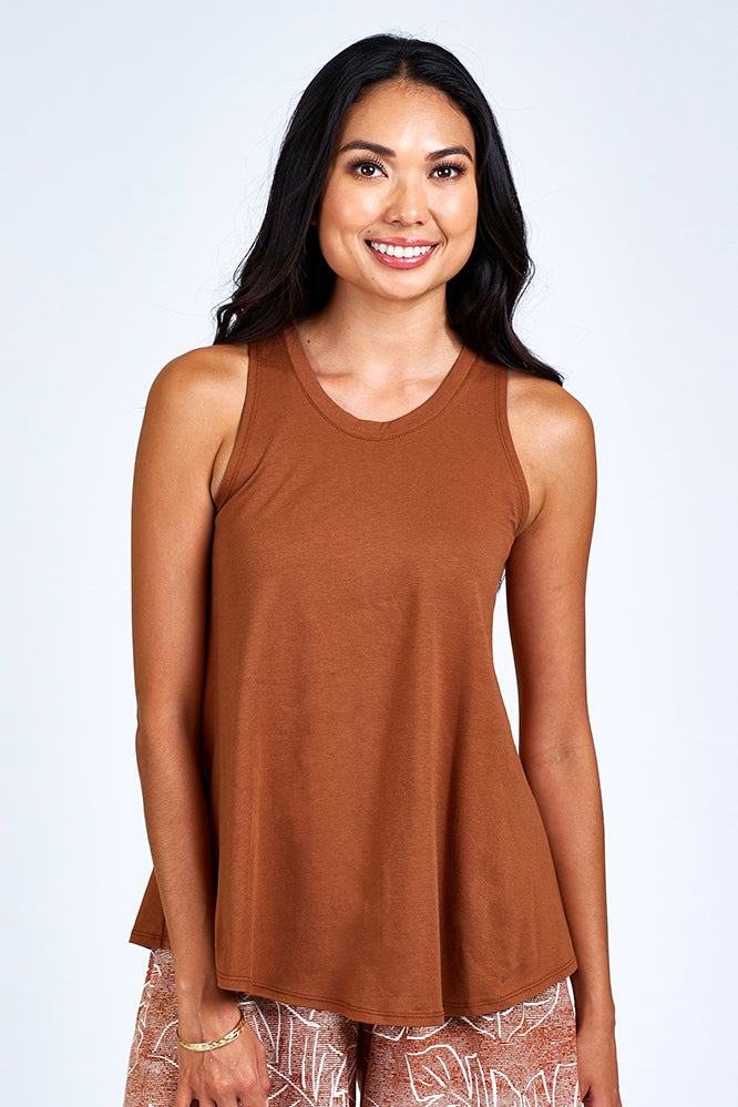Woman wearing rust and white shorts and rust color tank top.