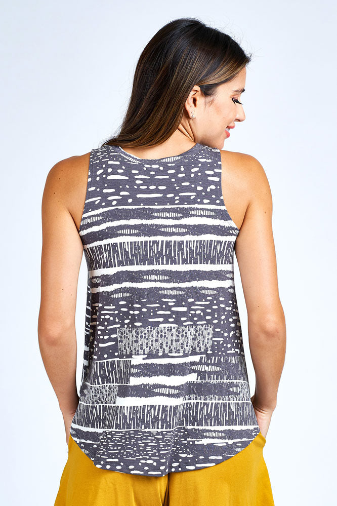 Woman wearing grey and white tank top.