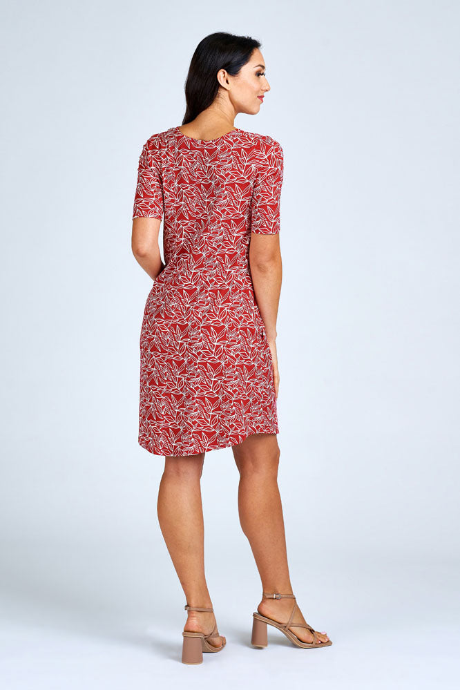 Woman wearing above knee red and cream dress.