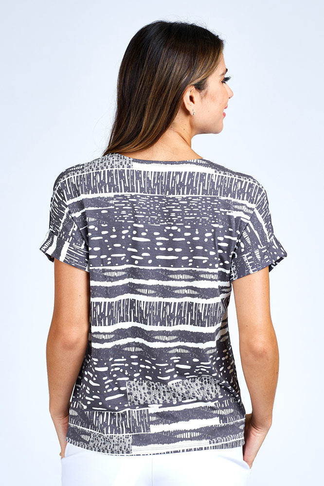 Woman wearing grey and white short sleeve top.