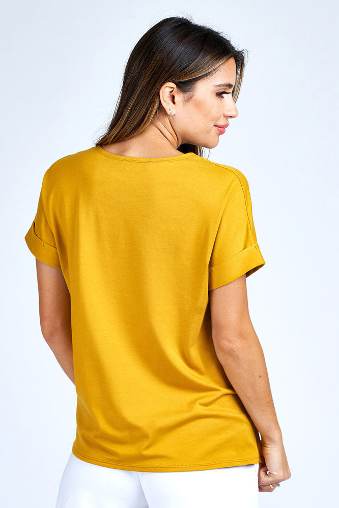 Woman wearing yellow short sleeve top.