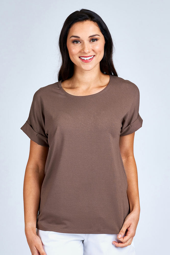 Woman wearing light brown short sleeve top.