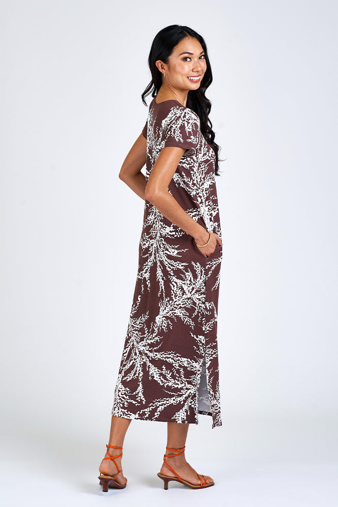 Woman wearing brown and white maxi dress.