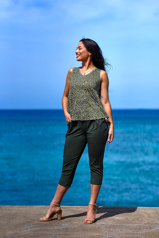 Woman wearing green print tank top and green pants.