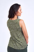 Woman wearing green print tank top and green pants.