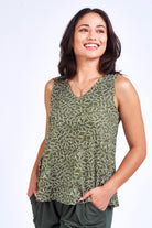 Woman wearing green print tank top and green pants.